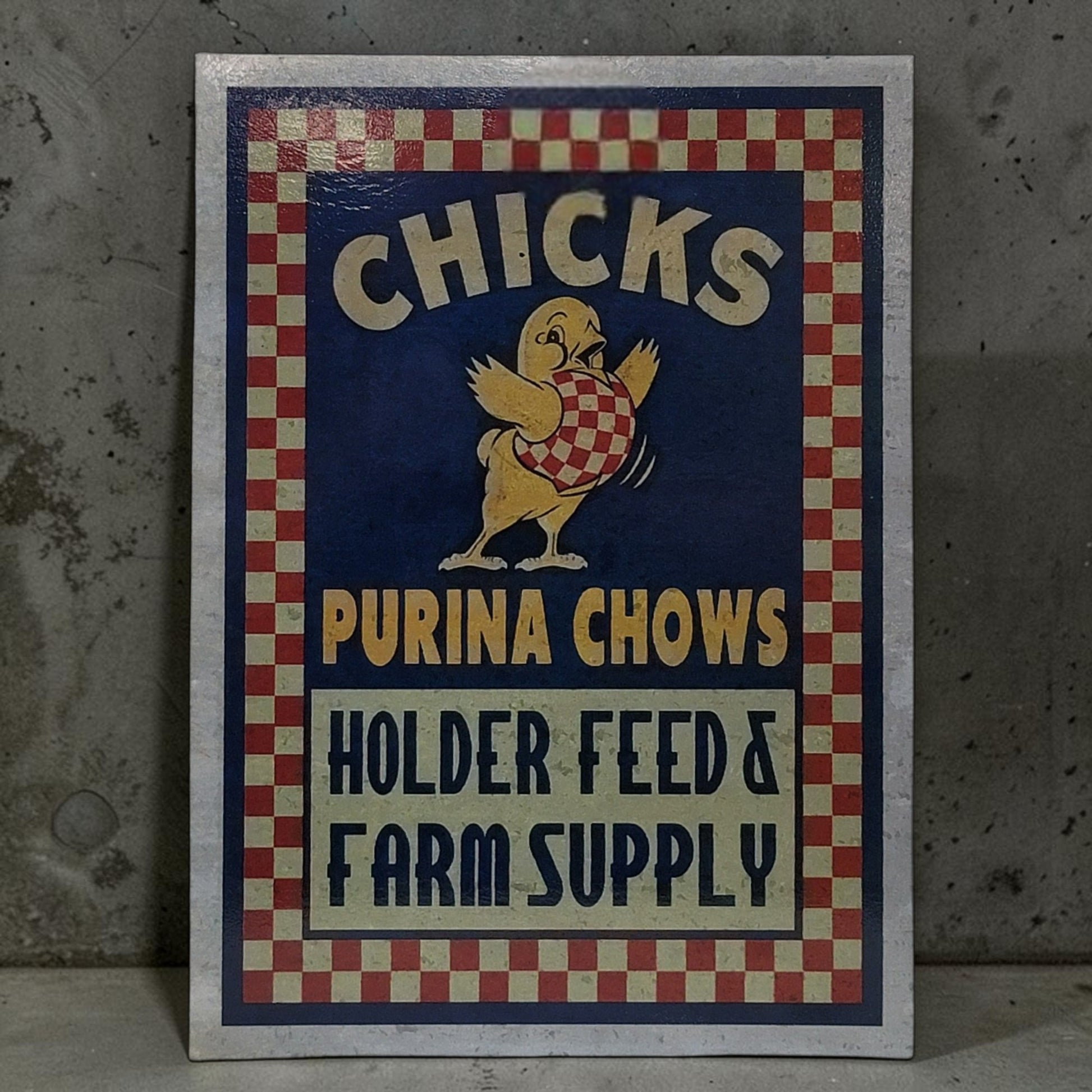 Vintage-style sign for Purina Chows with a chick illustration on a checkered border.
