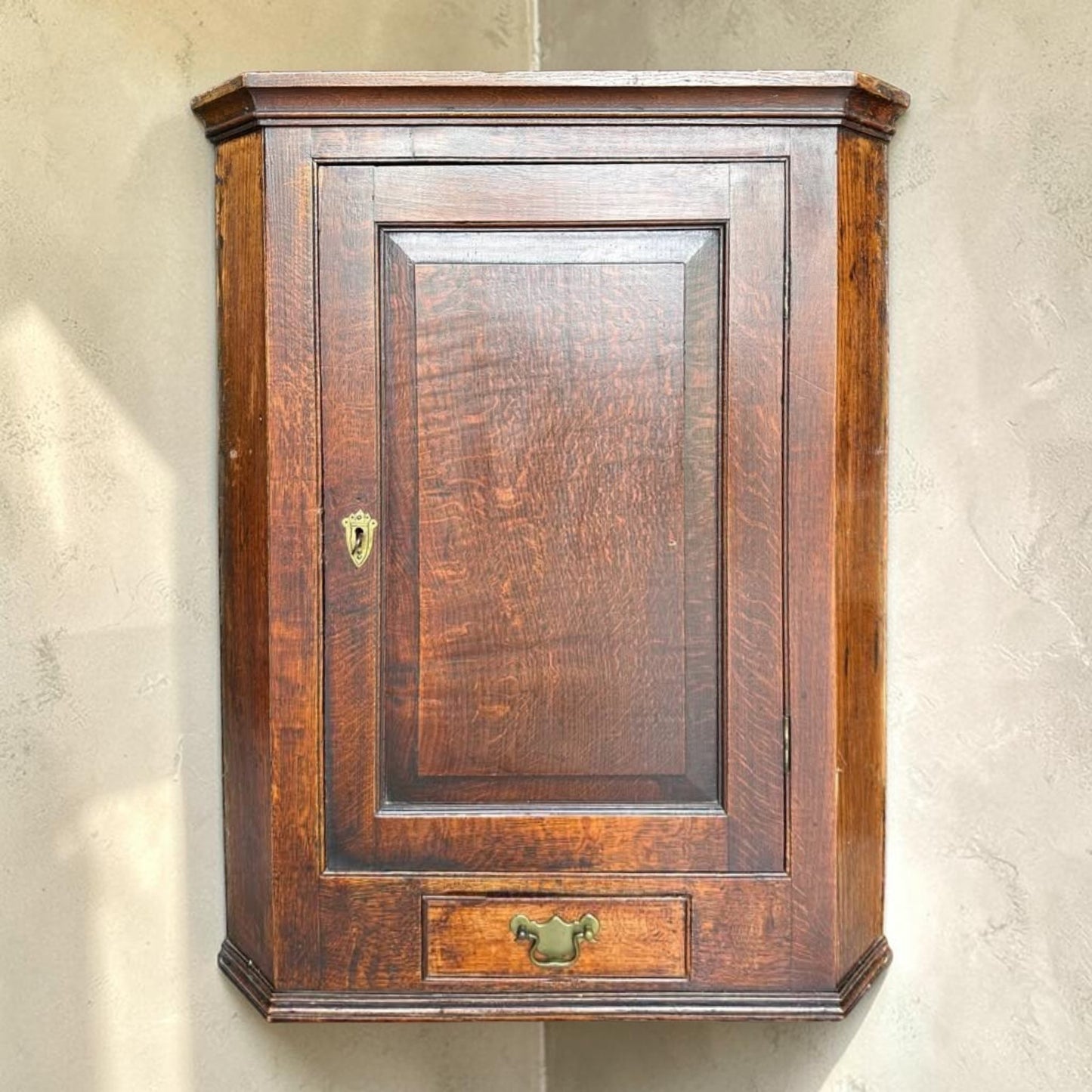 Antique Georgian quarter sawn oak hanging corner cupboard with dovetailed drawer.
