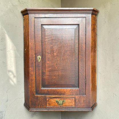 Antique Georgian quarter sawn oak hanging corner cupboard with dovetailed drawer.
