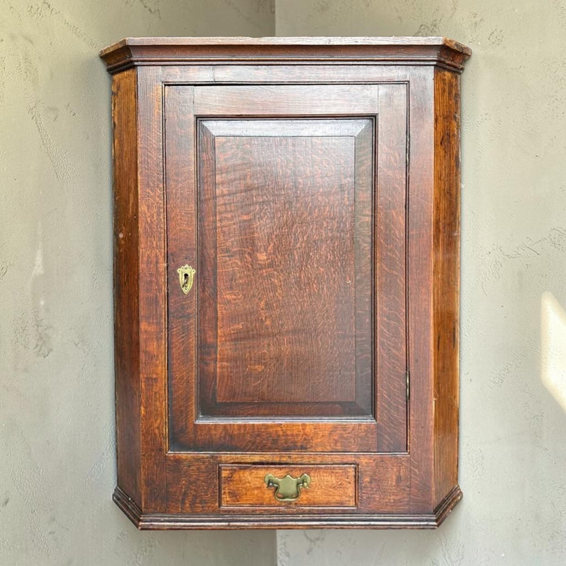 Antique Georgian quarter sawn oak hanging corner cupboard with dovetailed drawer.
