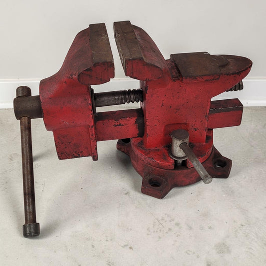 Vintage cast iron swivel base bench vise with 4-inch jaws and rear anvil.
