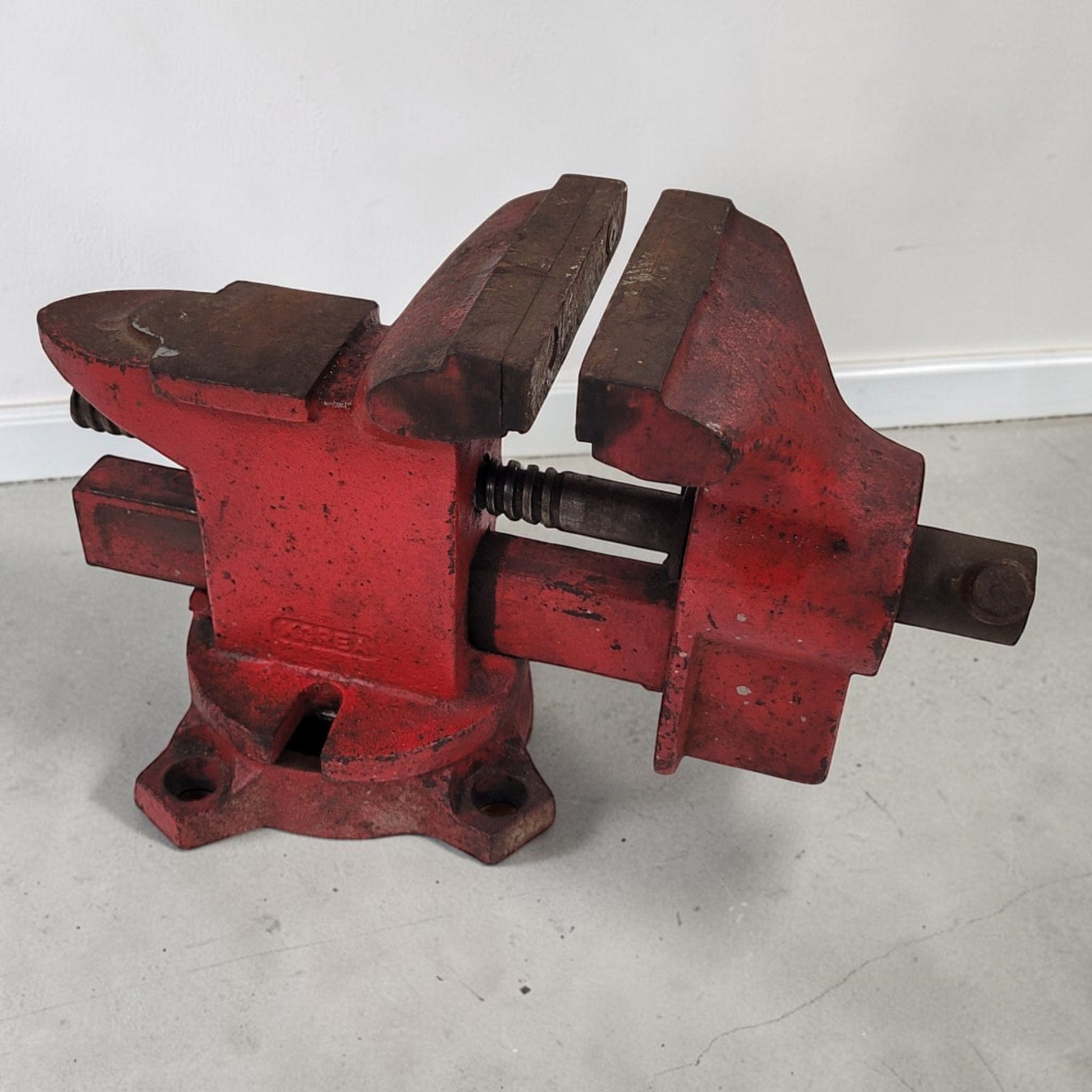 Vintage cast iron swivel base bench vise with 4-inch jaws and rear anvil.

