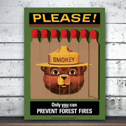 Smokey Bear poster with matches and 'Please!' text on a wooden surface.