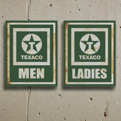 Two vintage-style Texaco restroom signs on a concrete wall.