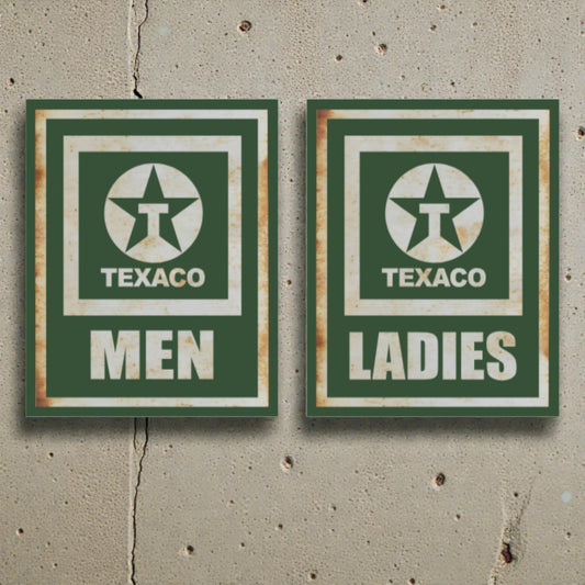 Two vintage-style Texaco restroom signs on a concrete wall.