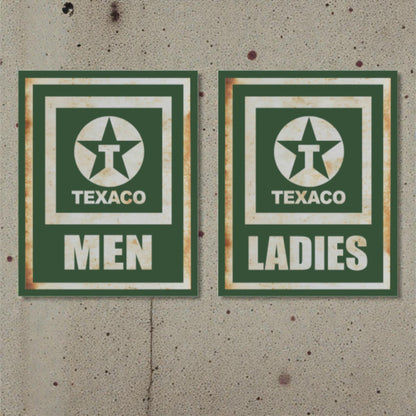 Two vintage Texaco restroom signs on a textured wall.