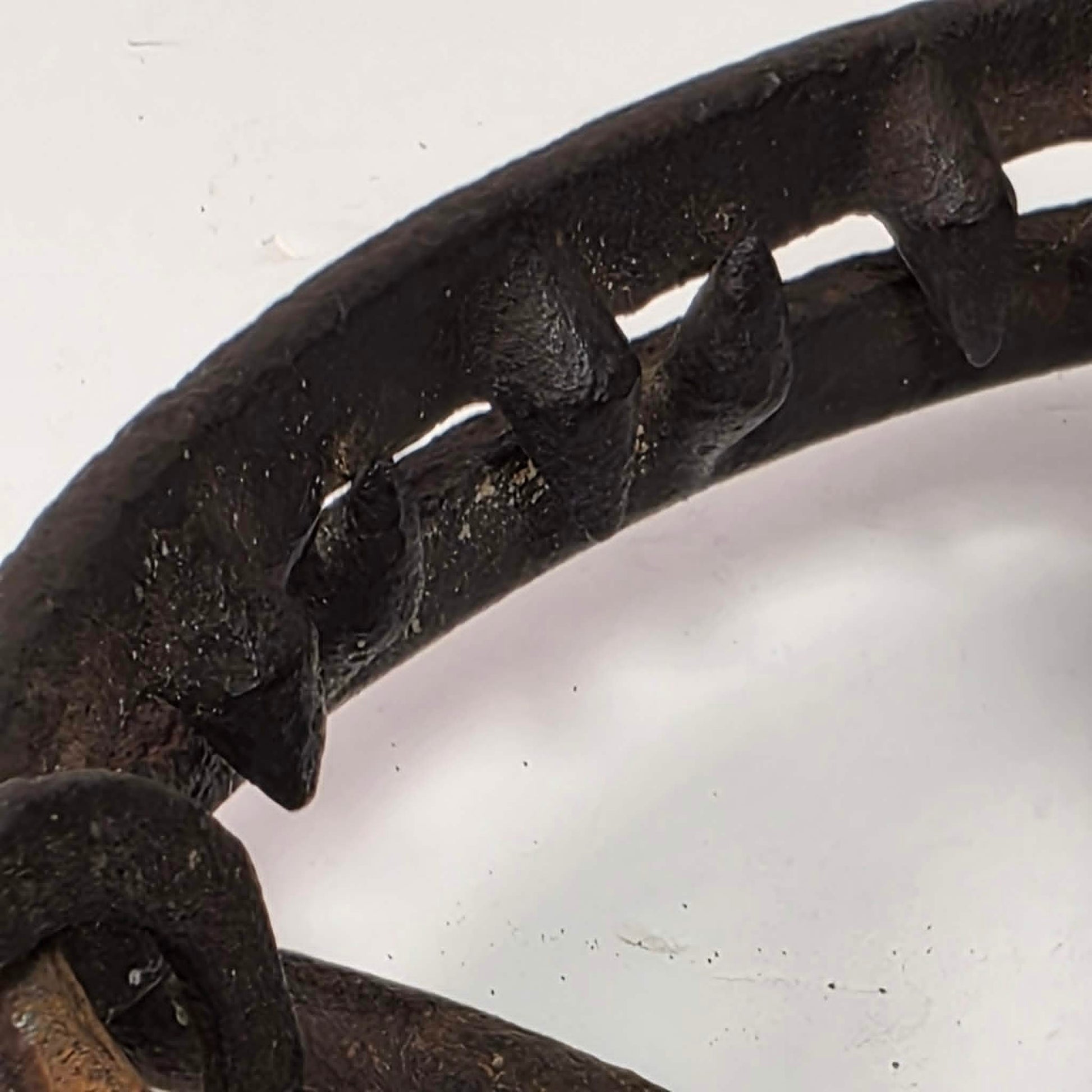 Antique Triumph 415X bear trap with toothed jaws and attached chain.

