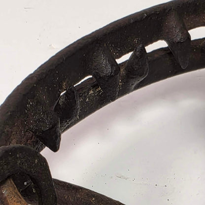 Antique Triumph 415X bear trap with toothed jaws and attached chain.
