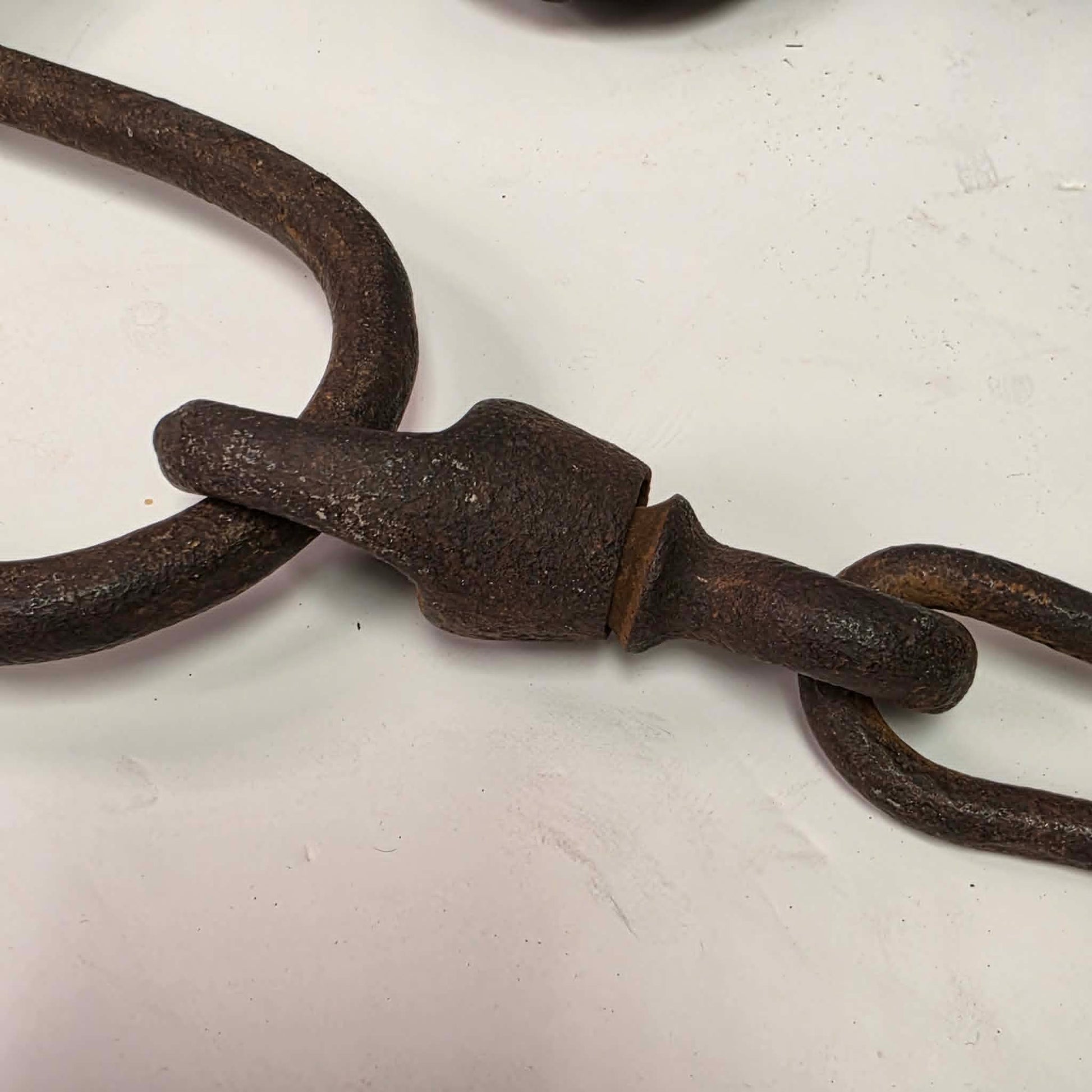 Antique Triumph 415X bear trap with toothed jaws and attached chain.
