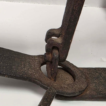 Antique Triumph 415X bear trap with toothed jaws and attached chain.
