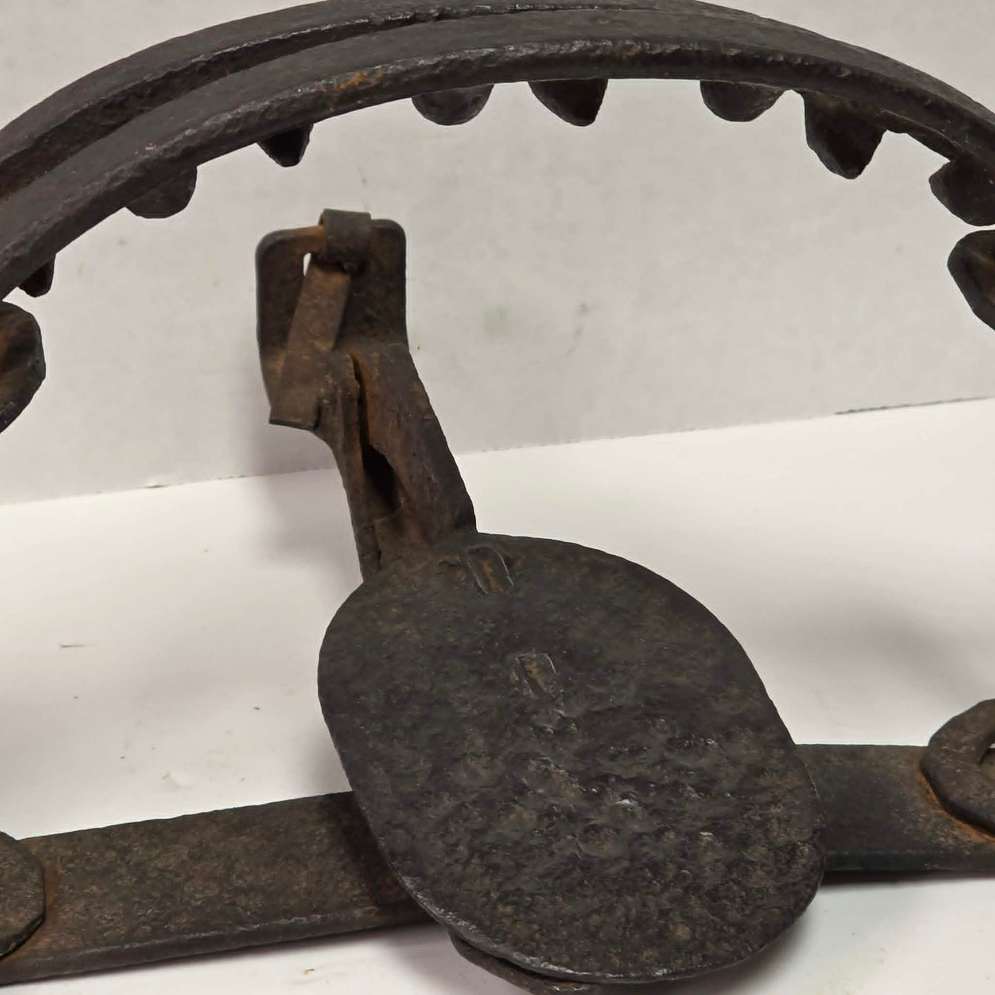 Antique Triumph 415X bear trap with toothed jaws and attached chain.
