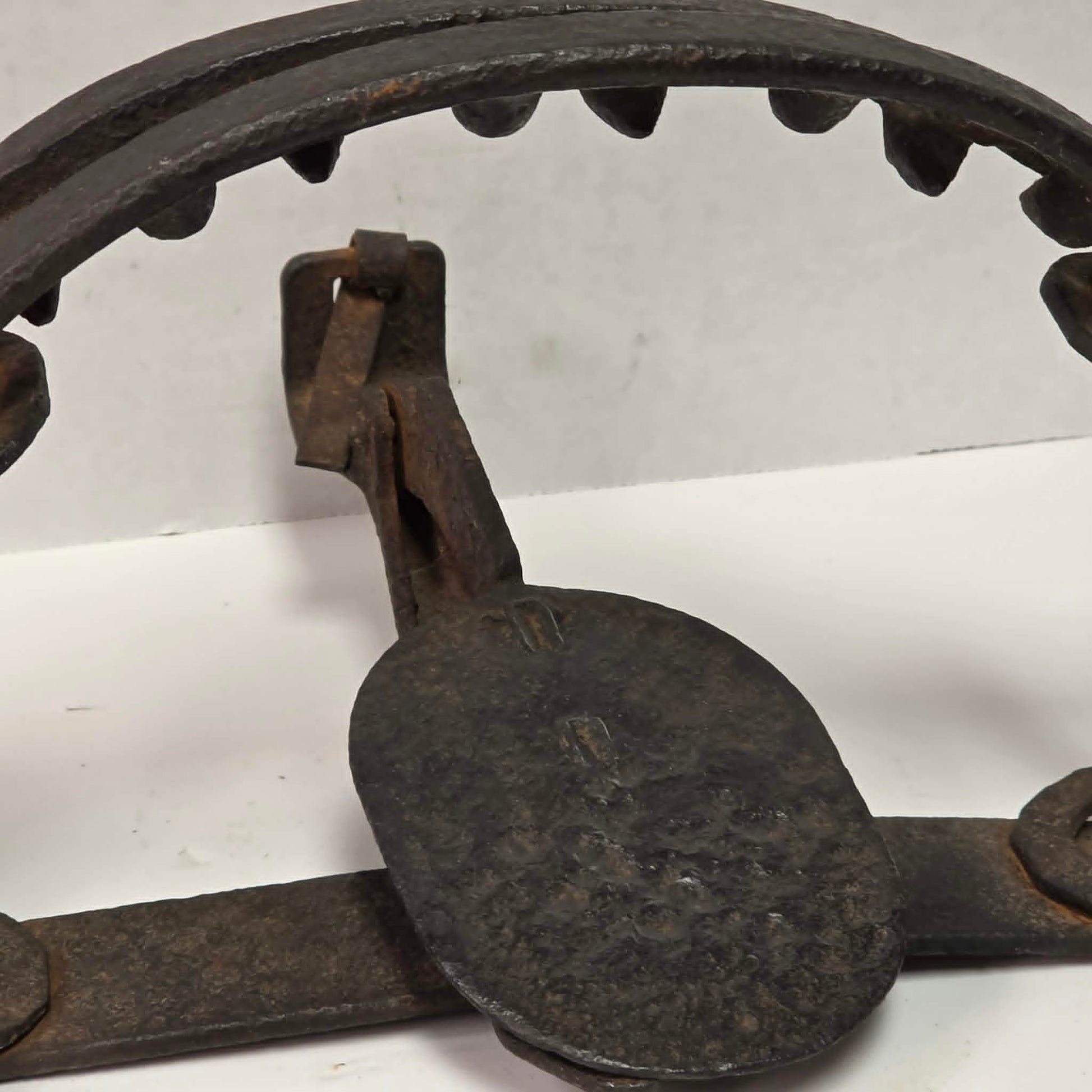Antique Triumph 415X bear trap with toothed jaws and attached chain.
