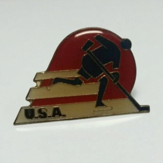 Pin with a silhouette of a person pushing a sled, set against a red and gold background, on a white background.