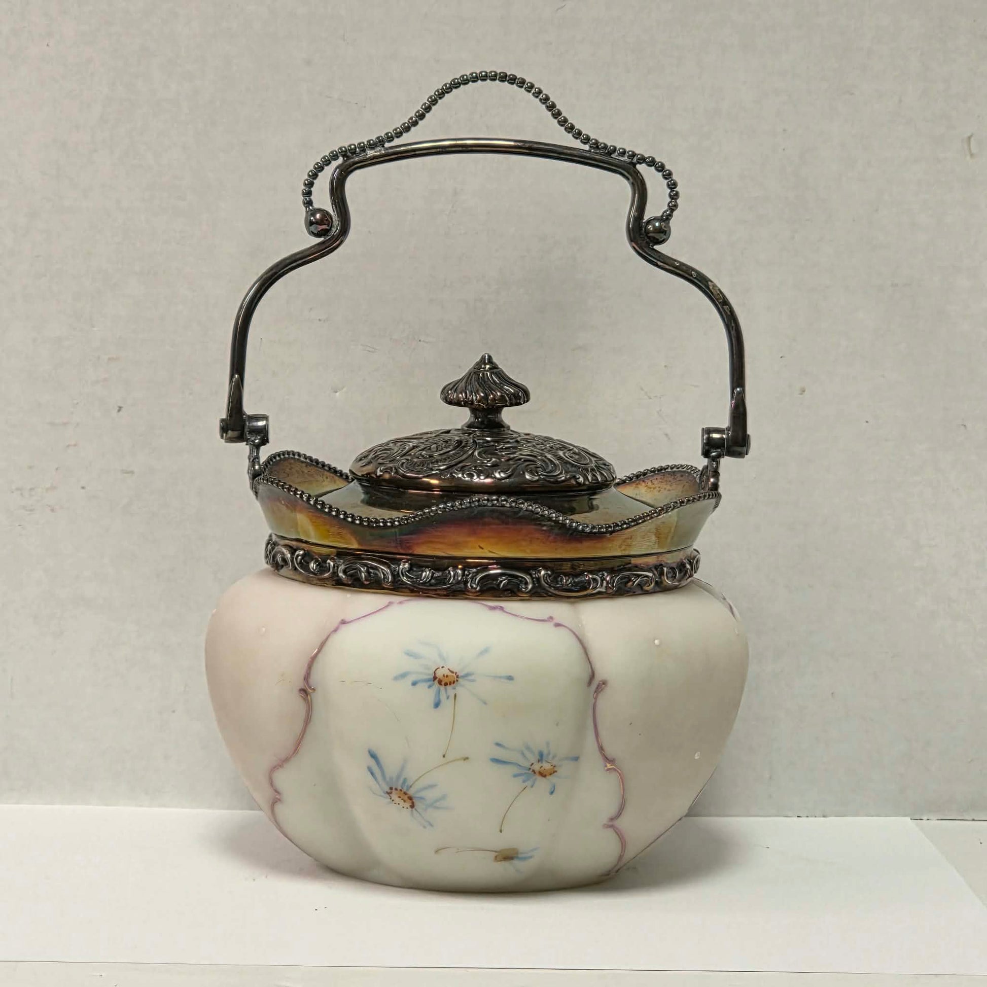 Victorian Mount Washington biscuit barrel with pastel pink and blue floral glass and ornate handle.
