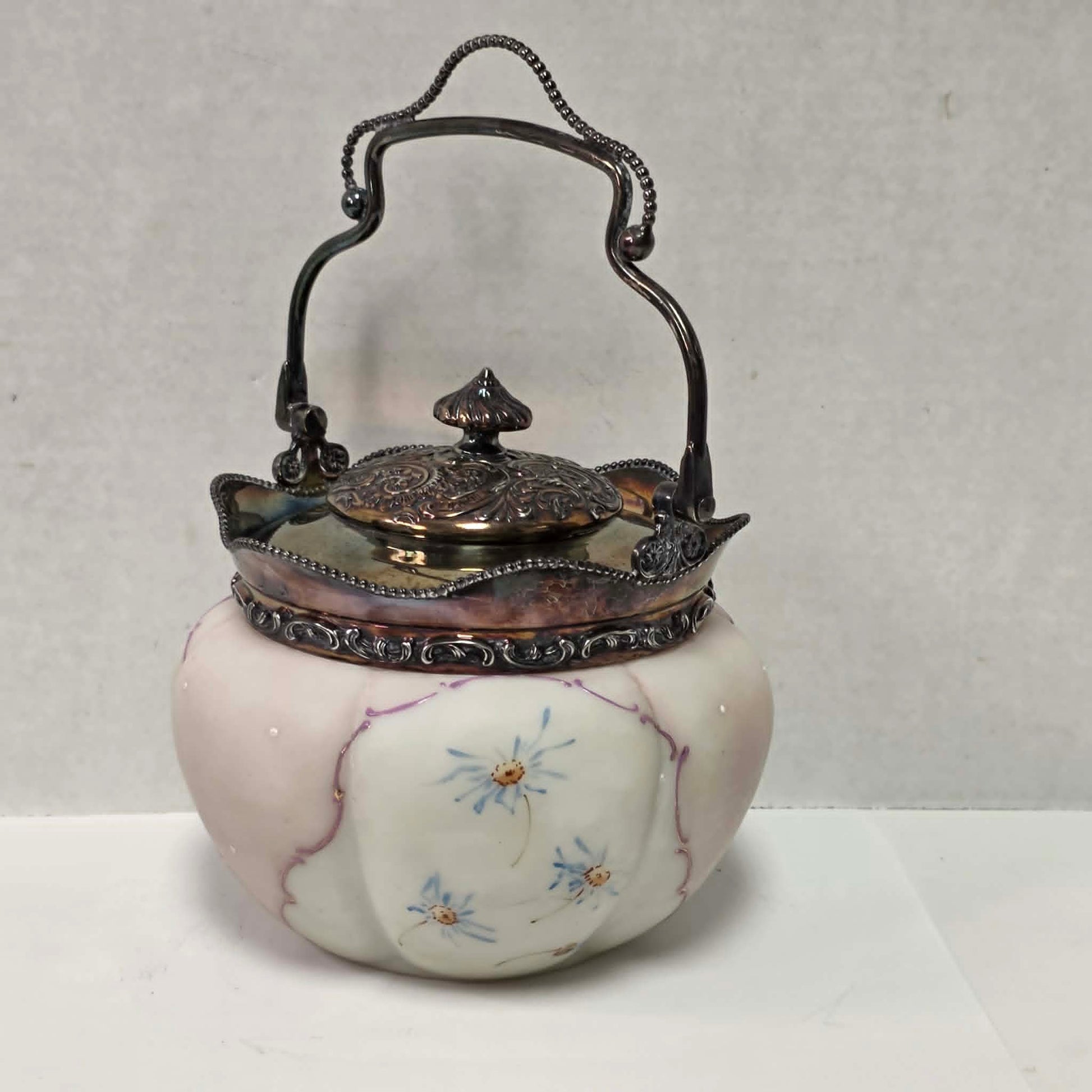 Victorian Mount Washington biscuit barrel with pastel pink and blue floral glass and ornate handle.
