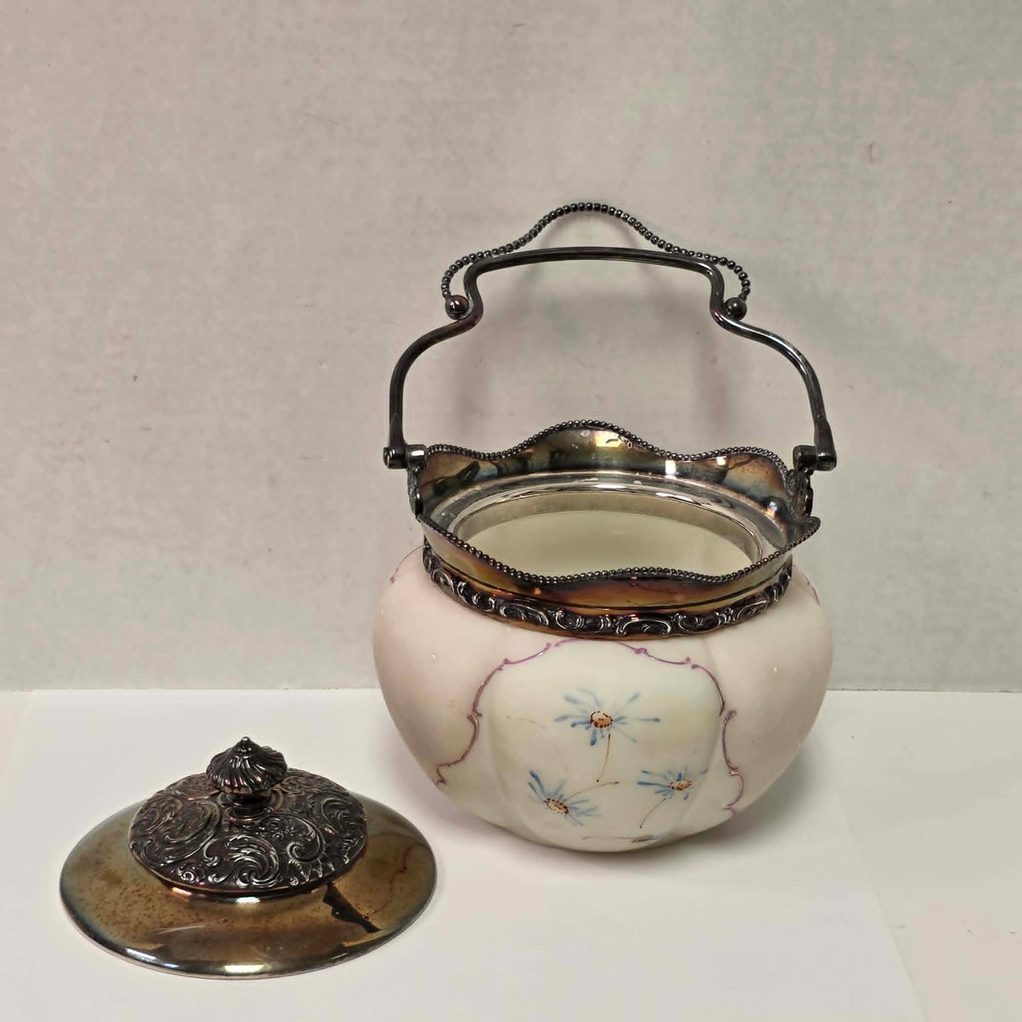 Victorian Mount Washington biscuit barrel with pastel pink and blue floral glass and ornate handle.

