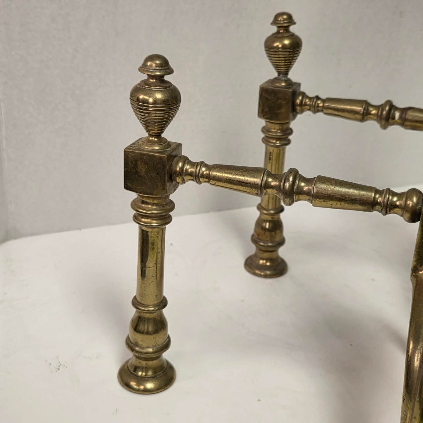 Victorian brass and bronze fireplace andirons with ornate figural bases and fluted ball finials.