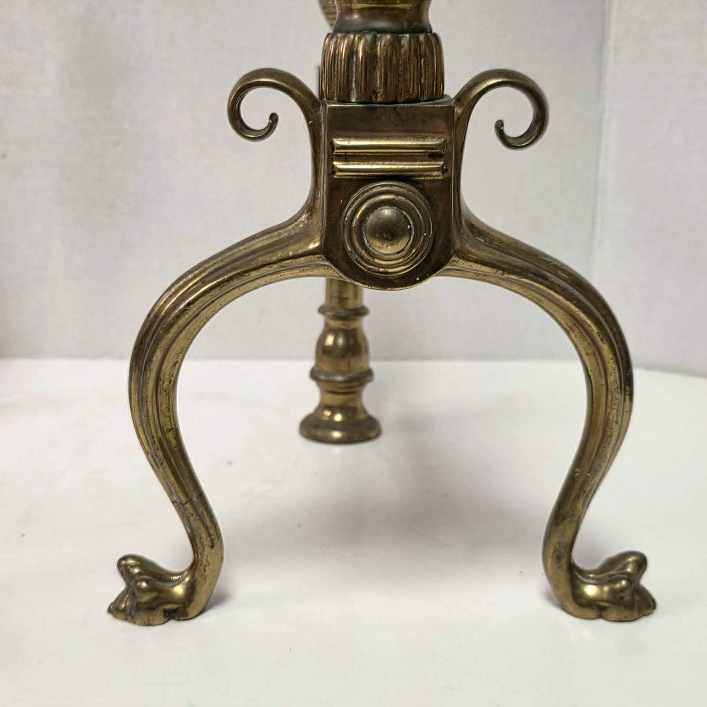Victorian brass and bronze fireplace andirons with ornate figural bases and fluted ball finials.