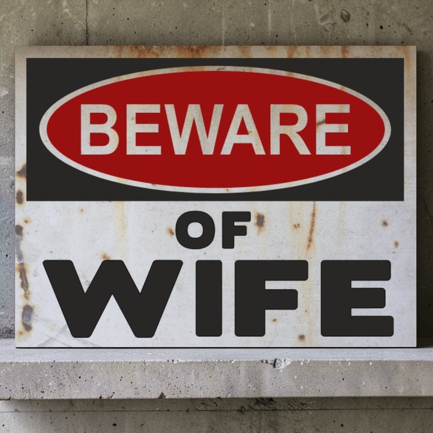 Rusticated sign with 'Beware of Wife' text on a concrete wall.