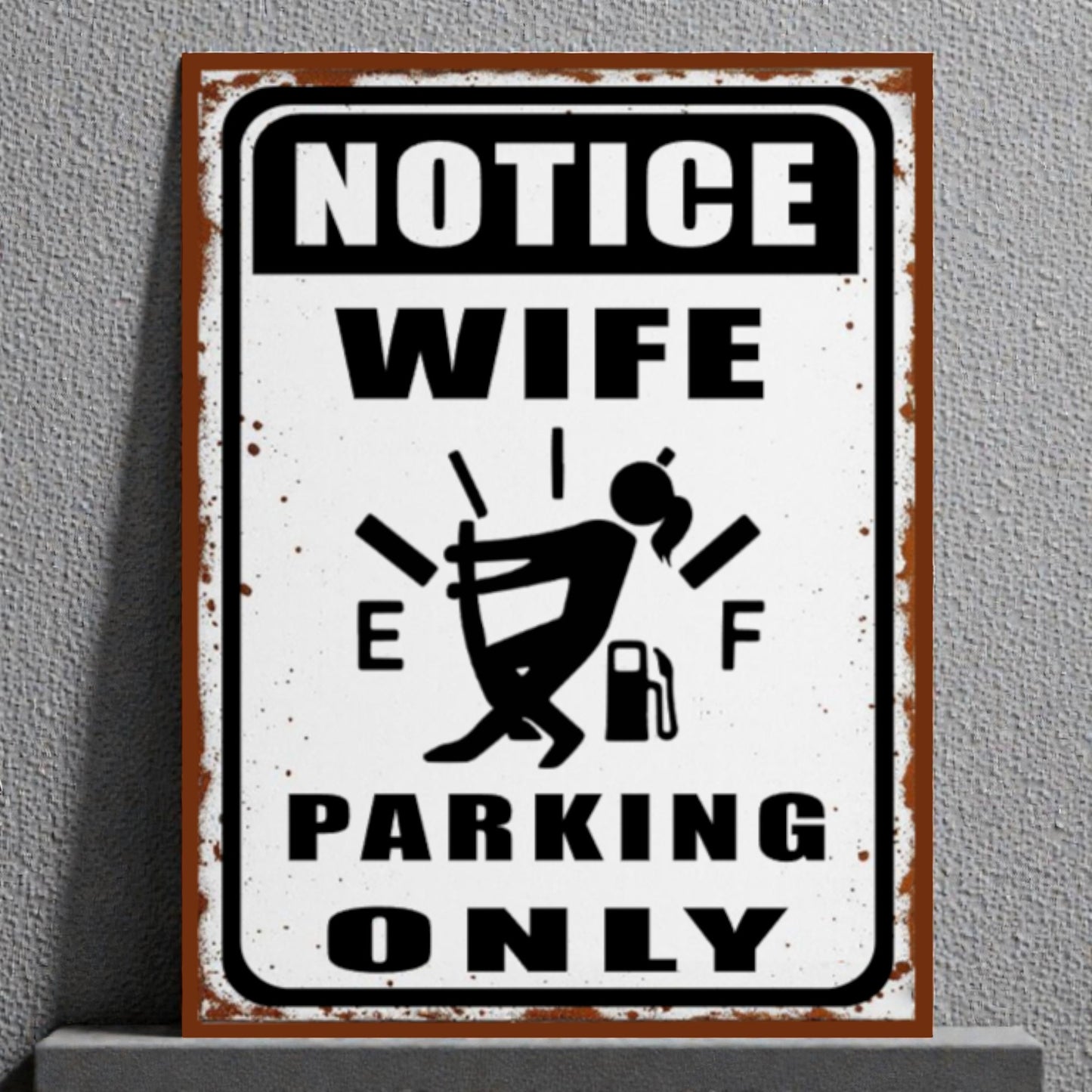 Metal sign with humorous design of a woman and text 'Notice Wife Parking Only' on a gray background