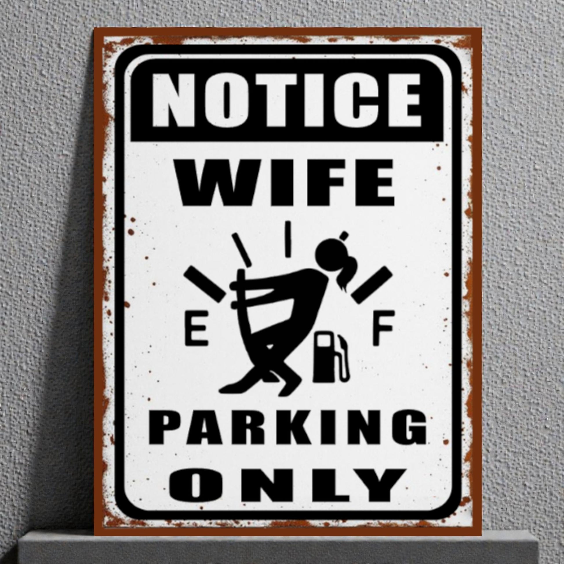 Metal sign with humorous design of a woman and text 'Notice Wife Parking Only' on a gray background