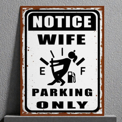 Metal sign with humorous design of a woman and text 'Notice Wife Parking Only' on a gray background