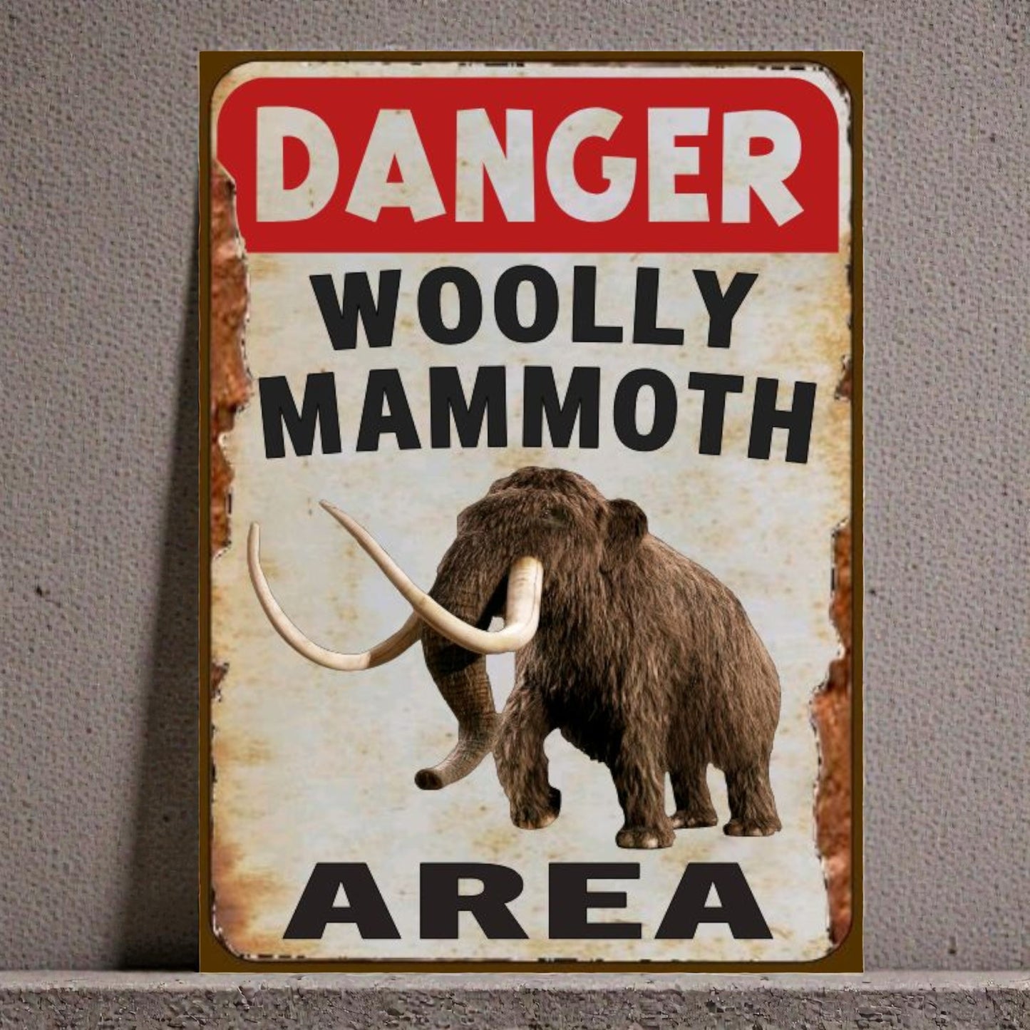 Vintage-style sign with a woolly mammoth illustration and 'Danger Woolly Mammoth Area' text on a textured background.