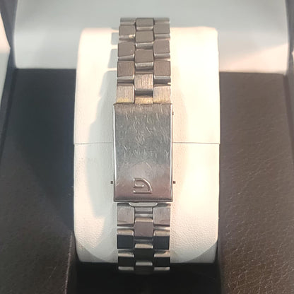 Silver watch with a brand logo on a white cushion