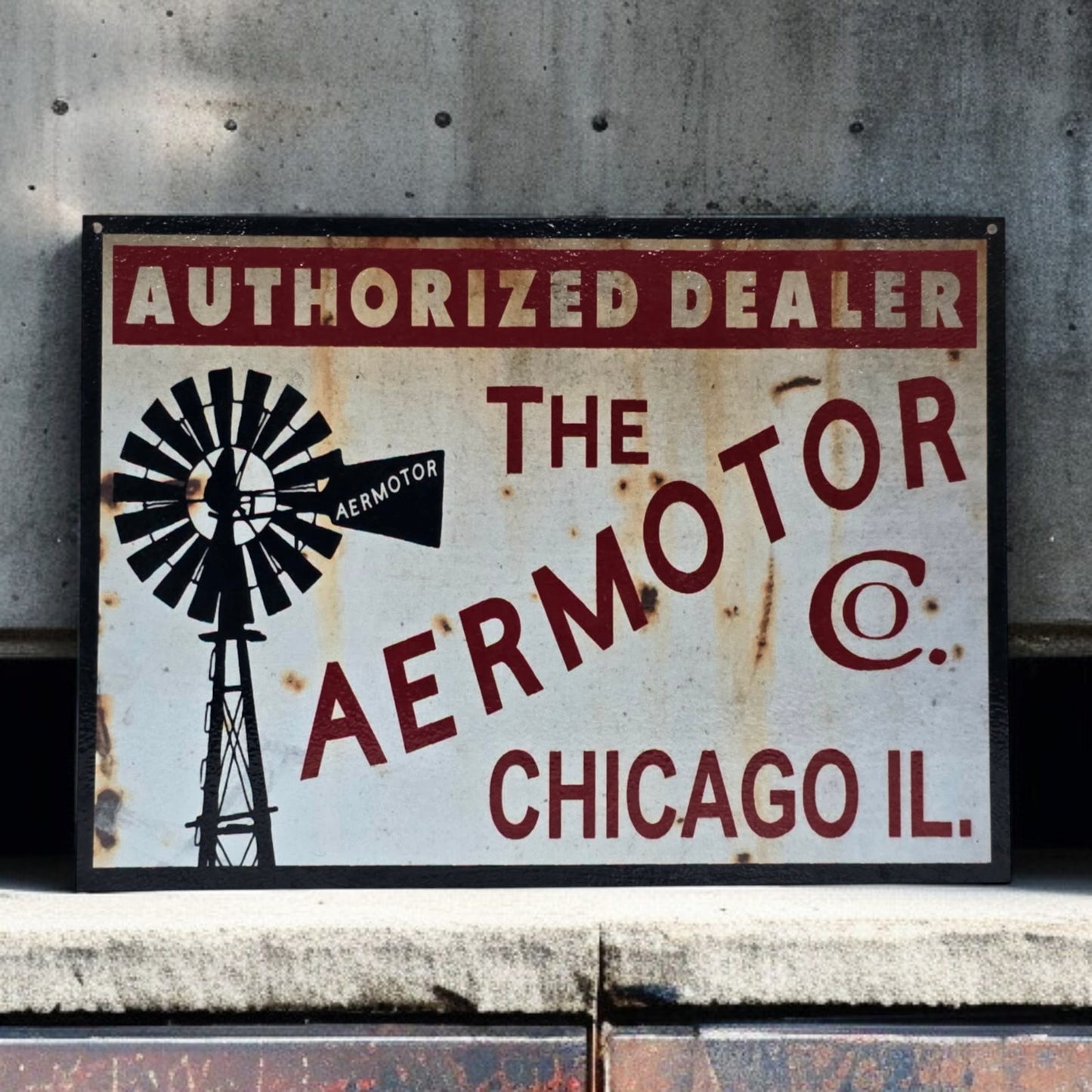 Vintage-style sign for Aermotor Co. with a windmill graphic on a concrete background