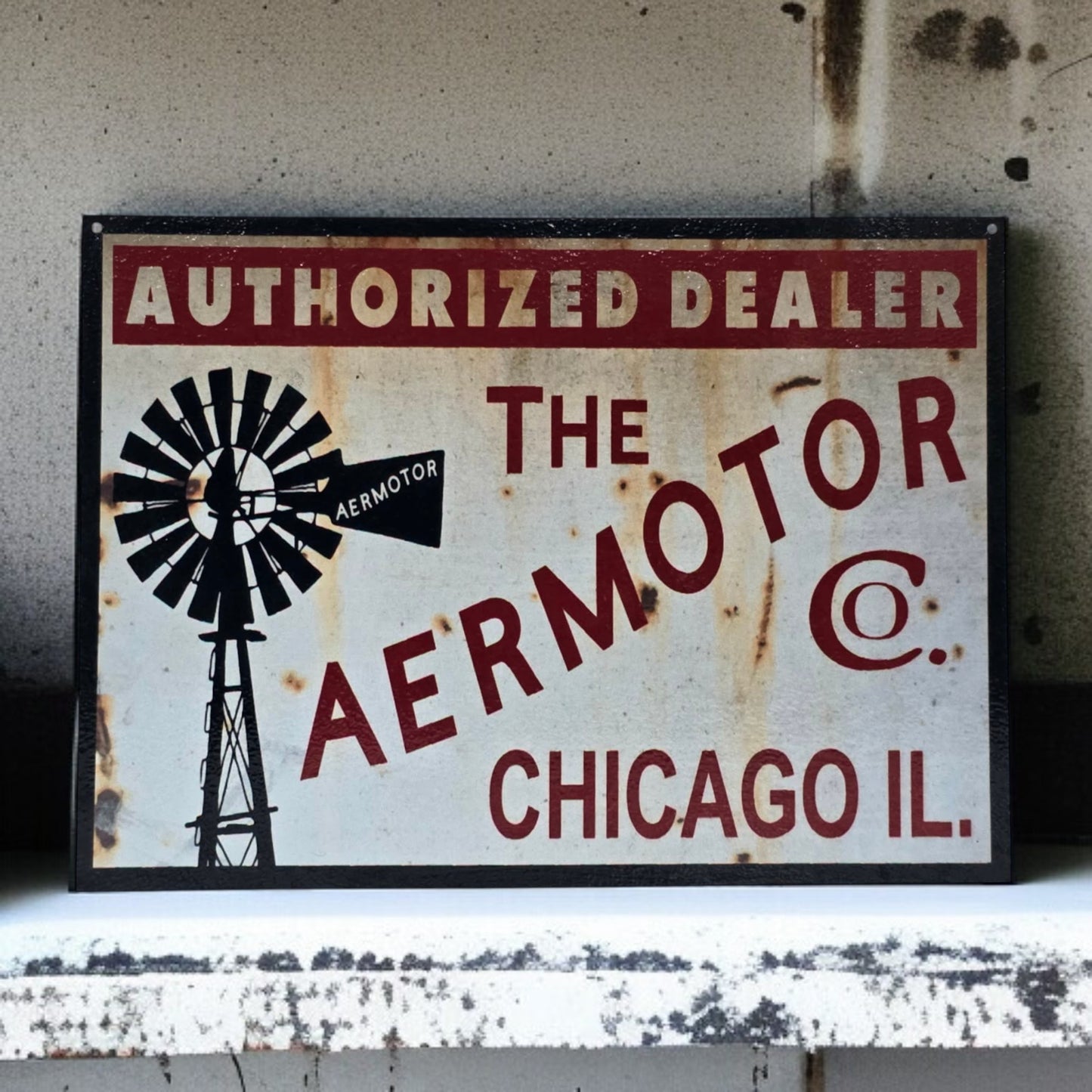 Vintage sign for Aermotor Co. with a windmill graphic on a textured wall.
