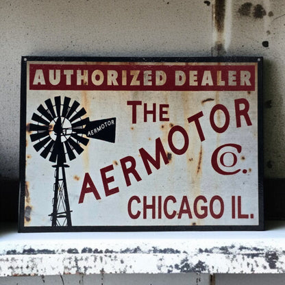 Vintage sign for Aermotor Co. with a windmill graphic on a textured wall.