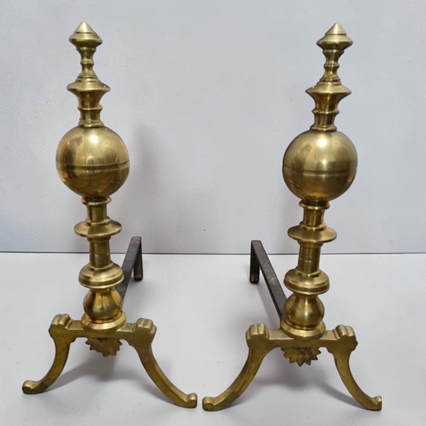 Antique brass and iron ornate fireplace andirons used as decorative hearth log holders.