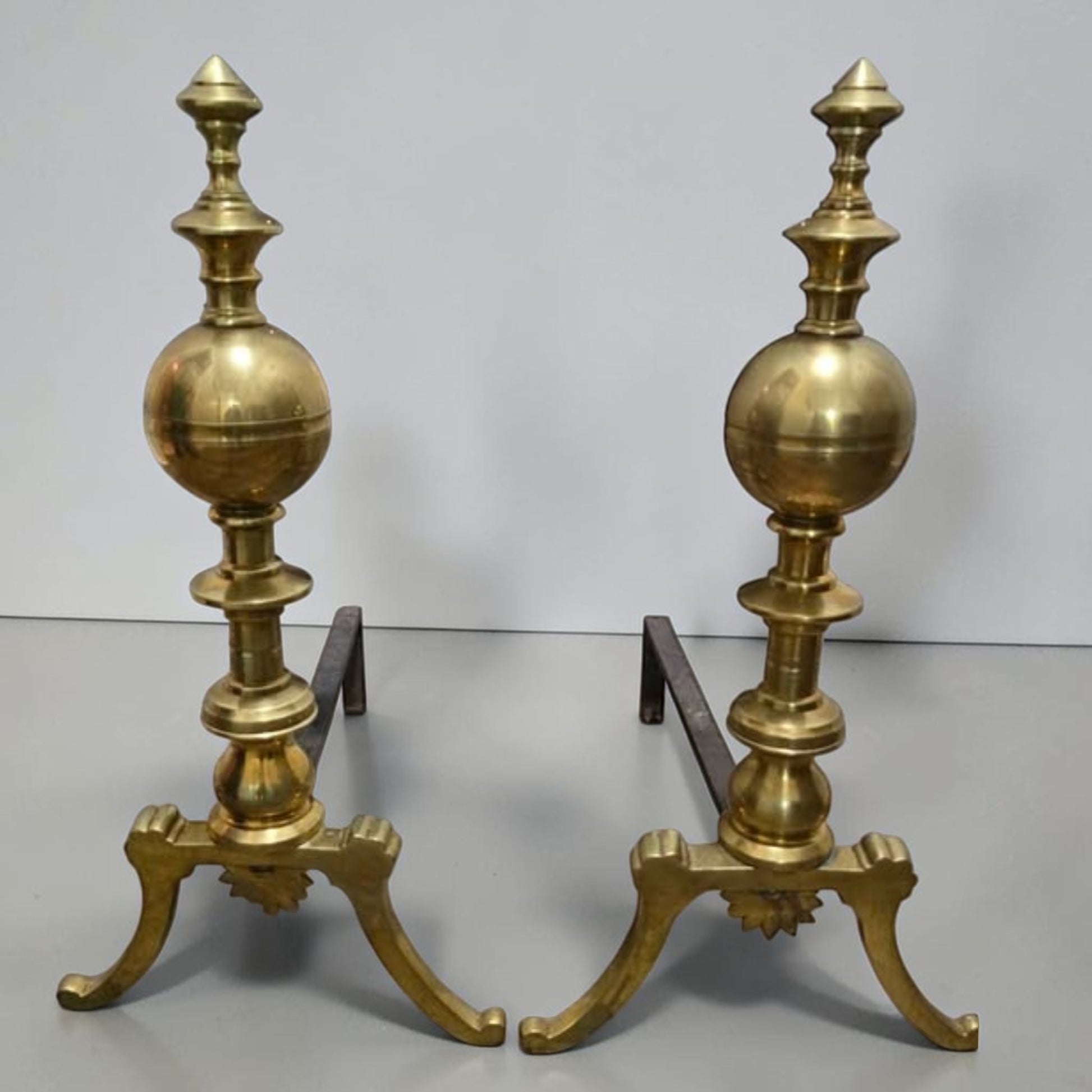 Antique brass and iron ornate fireplace andirons used as decorative hearth log holders.