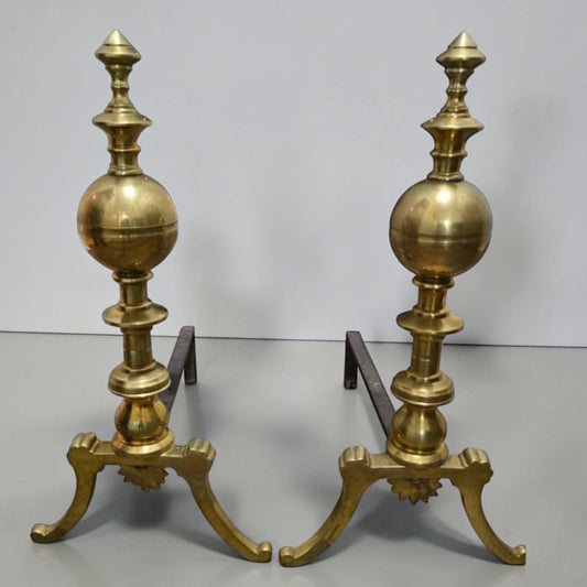 Antique brass and iron ornate fireplace andirons used as decorative hearth log holders.