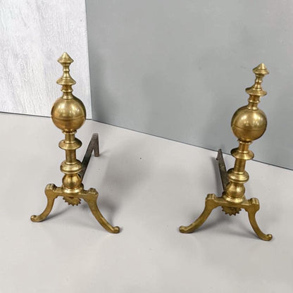 Antique brass and iron ornate fireplace andirons used as decorative hearth log holders.