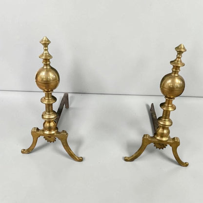 Antique brass and iron ornate fireplace andirons used as decorative hearth log holders.