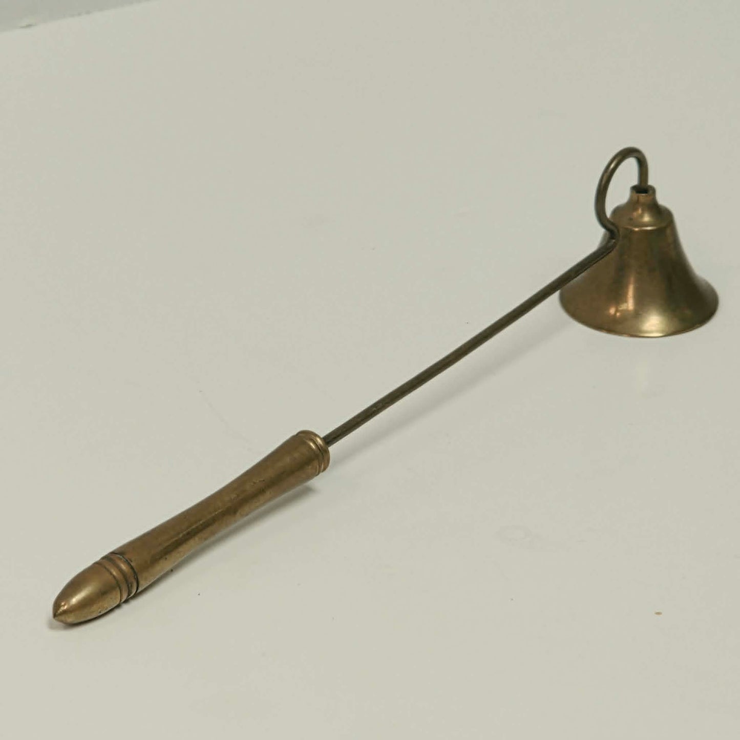 Antique solid brass candle snuffer with threaded handle and original patina.

