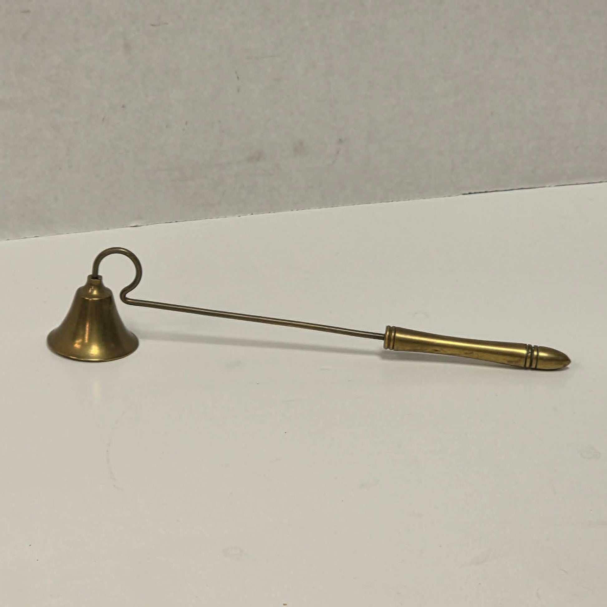Antique solid brass candle snuffer with threaded handle and original patina.
