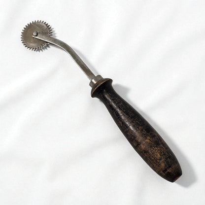 Vintage metal tool with wooden handle on a white background
