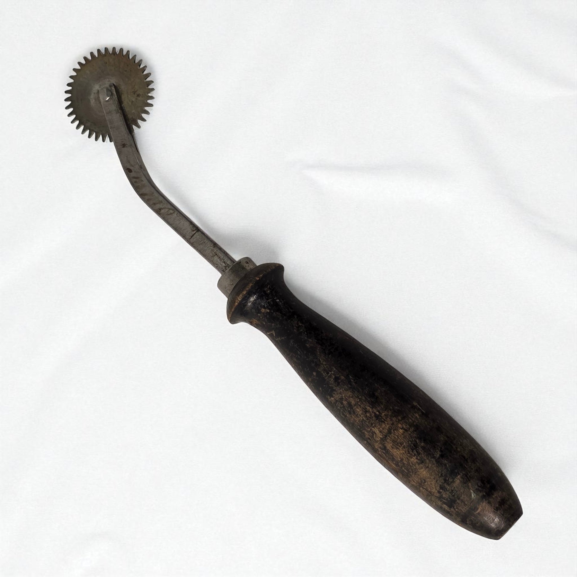Vintage metal tool with a handle on a white background