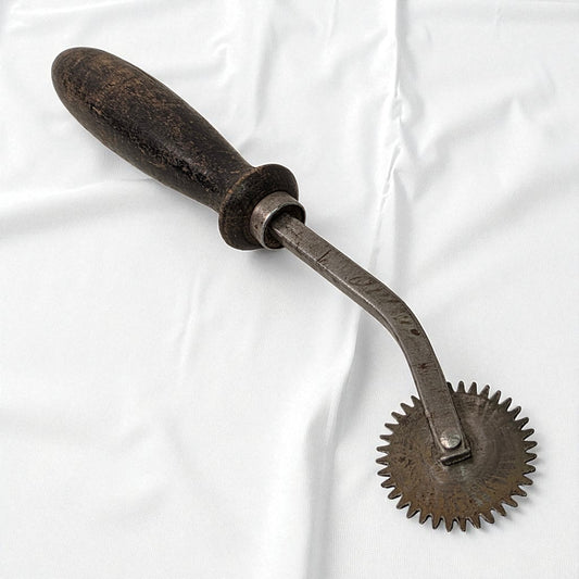 Vintage metal tool with a handle on a white background