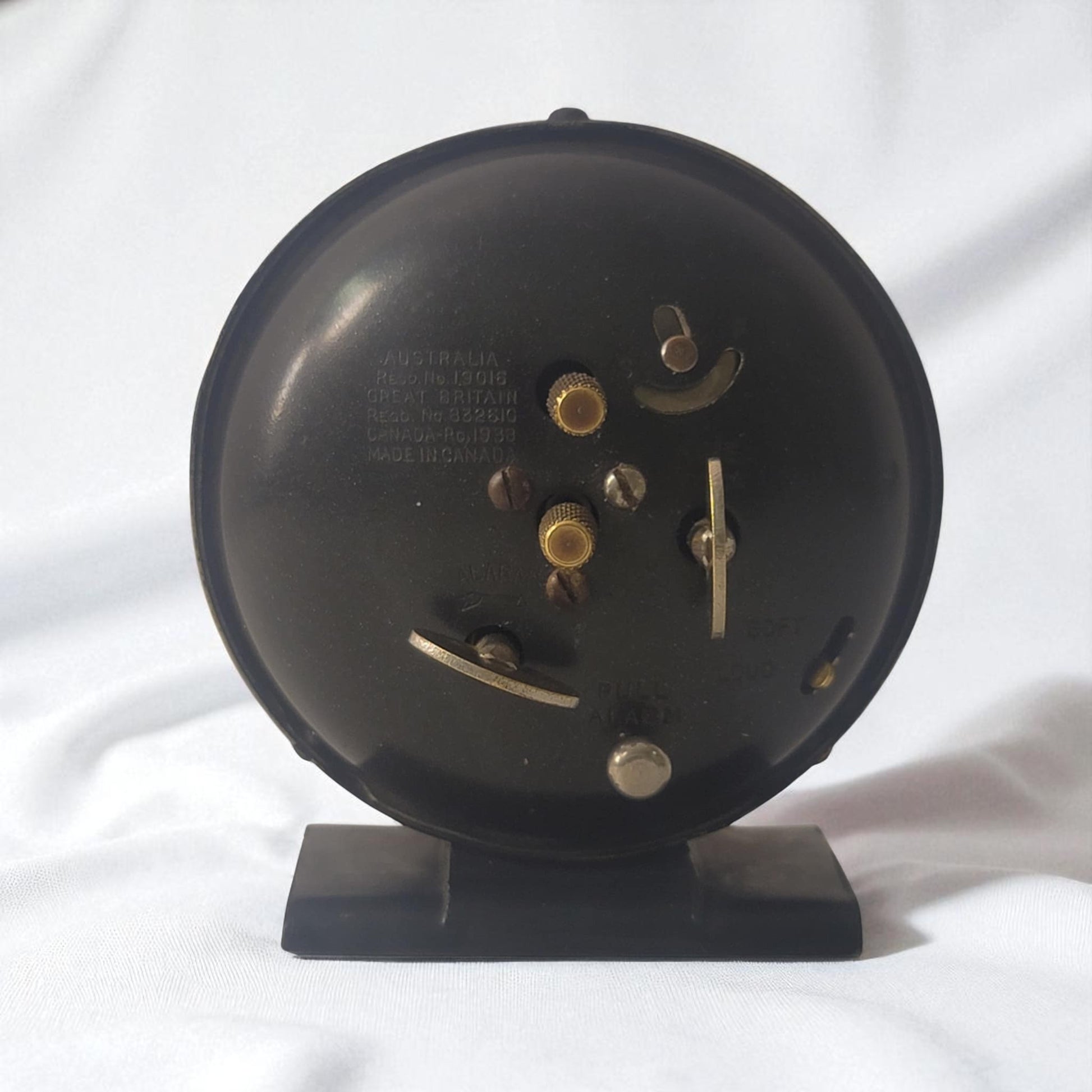 Black round clock with visible gears on a white background