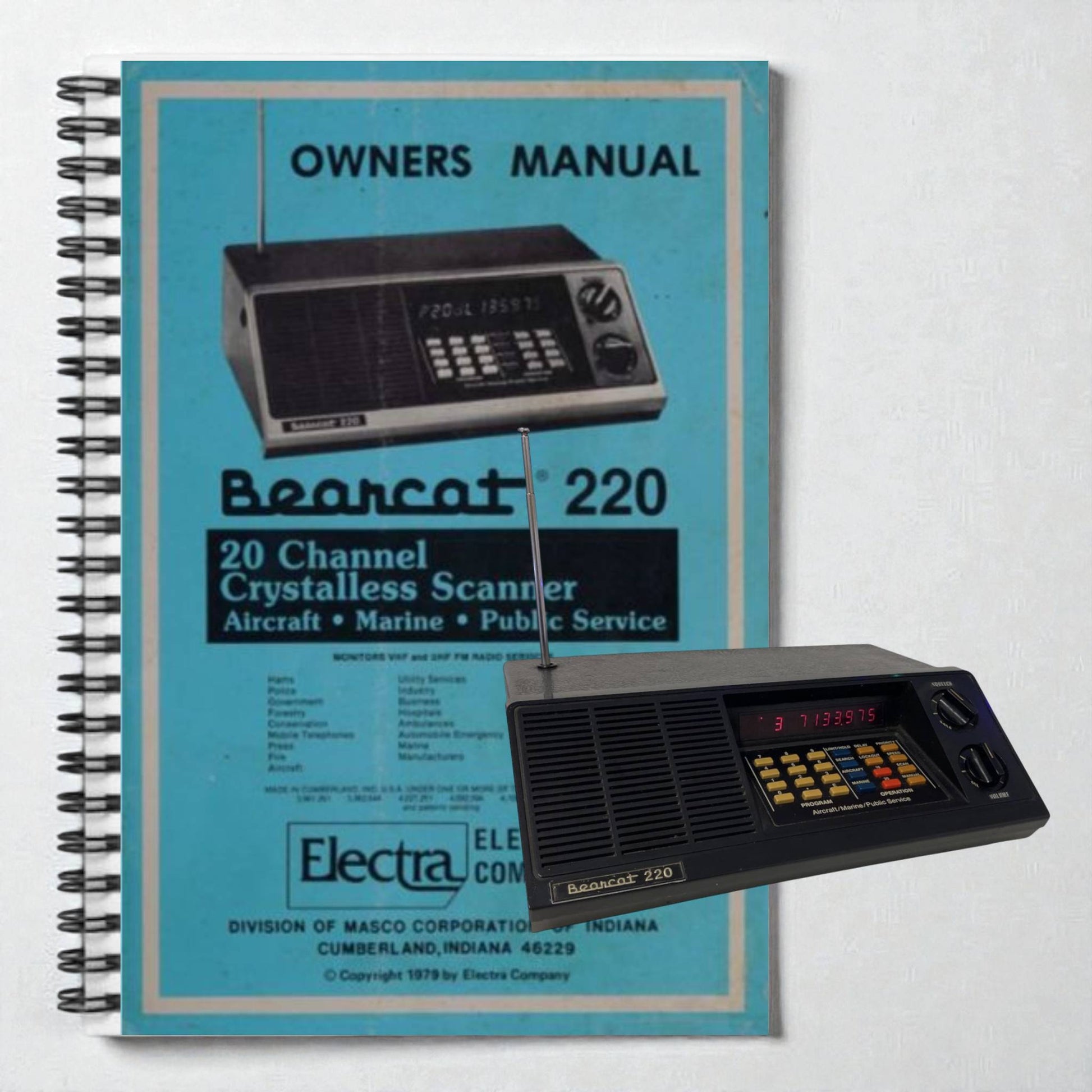 Vintage Bearcat 220 scanner with its owner's manual on a light gray background