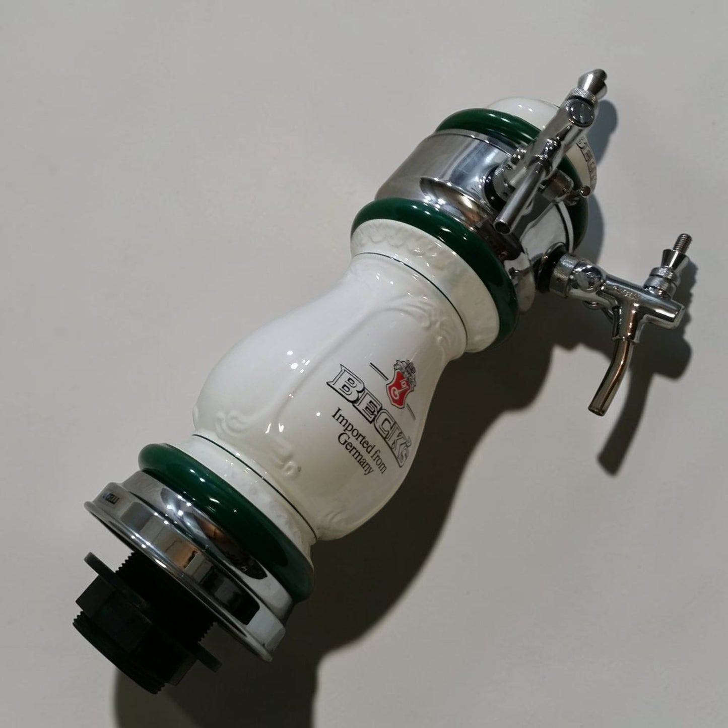 Classic Beck’s Beer porcelain keg head with dual spouts, ideal for bar or brewery display.