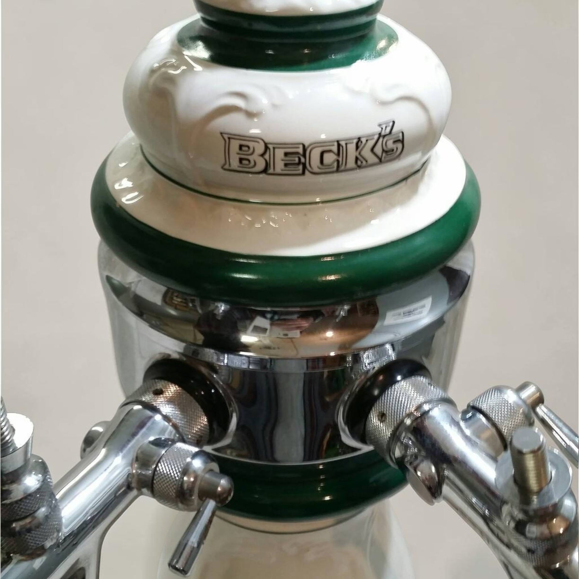 Classic Beck’s Beer porcelain keg head with dual spouts, ideal for bar or brewery display.