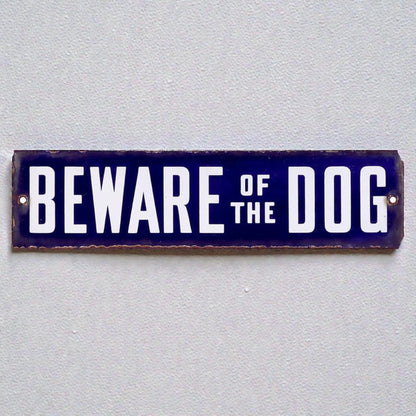 metal sign with 'Beware of the Dog' text on a gray background