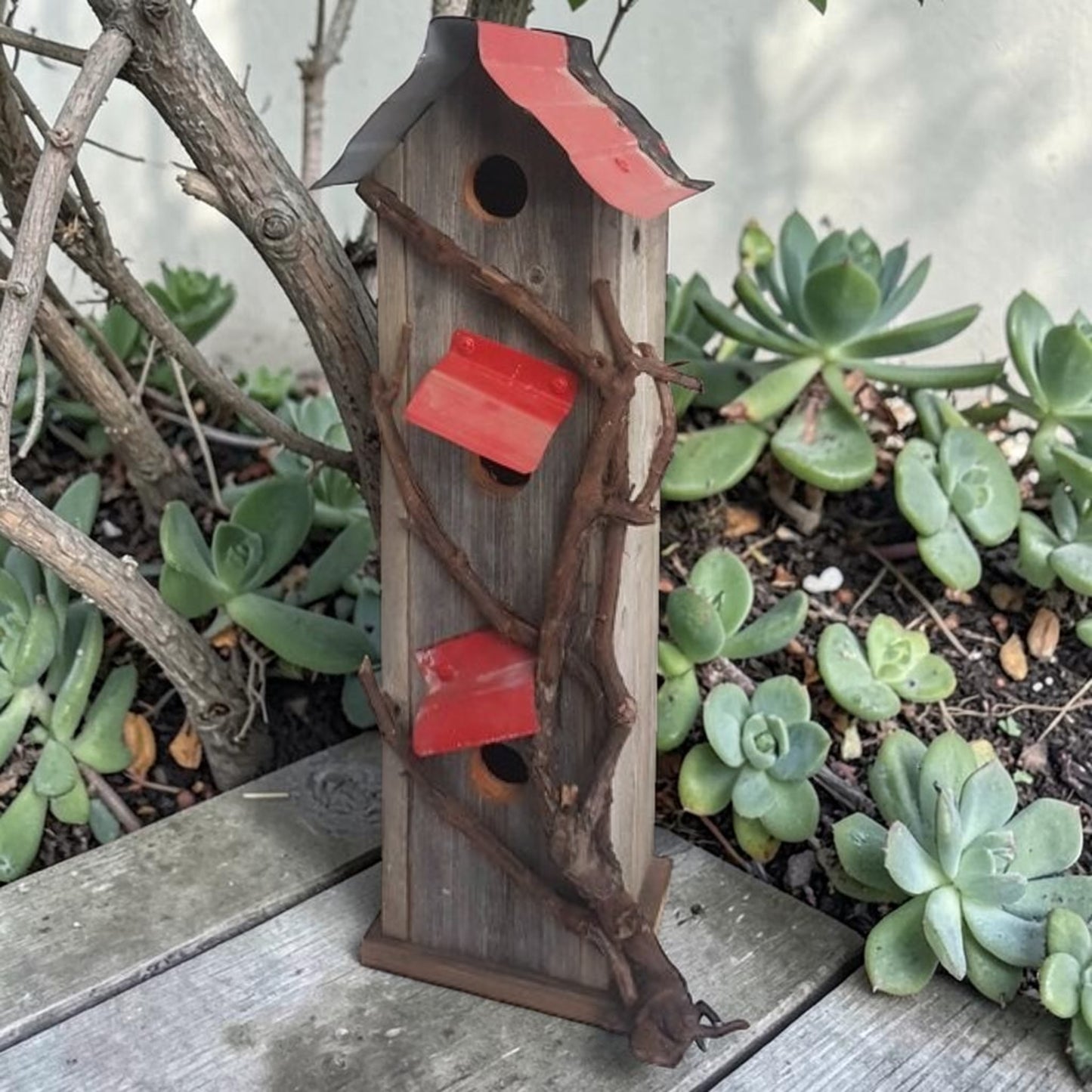Handcrafted reclaimed cedar and barn tin birdhouse with three nesting spots.