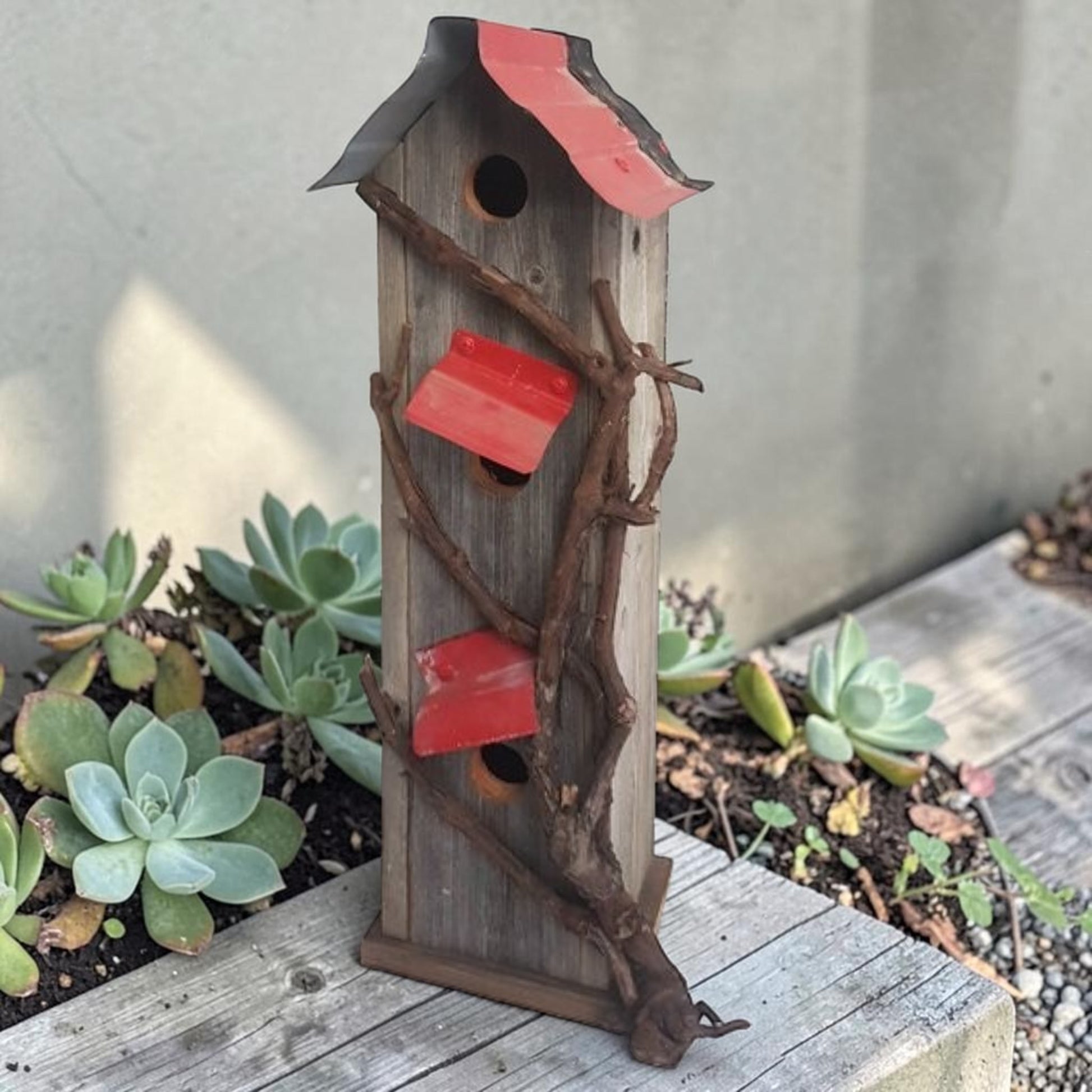 Handcrafted reclaimed cedar and barn tin birdhouse with three nesting spots.