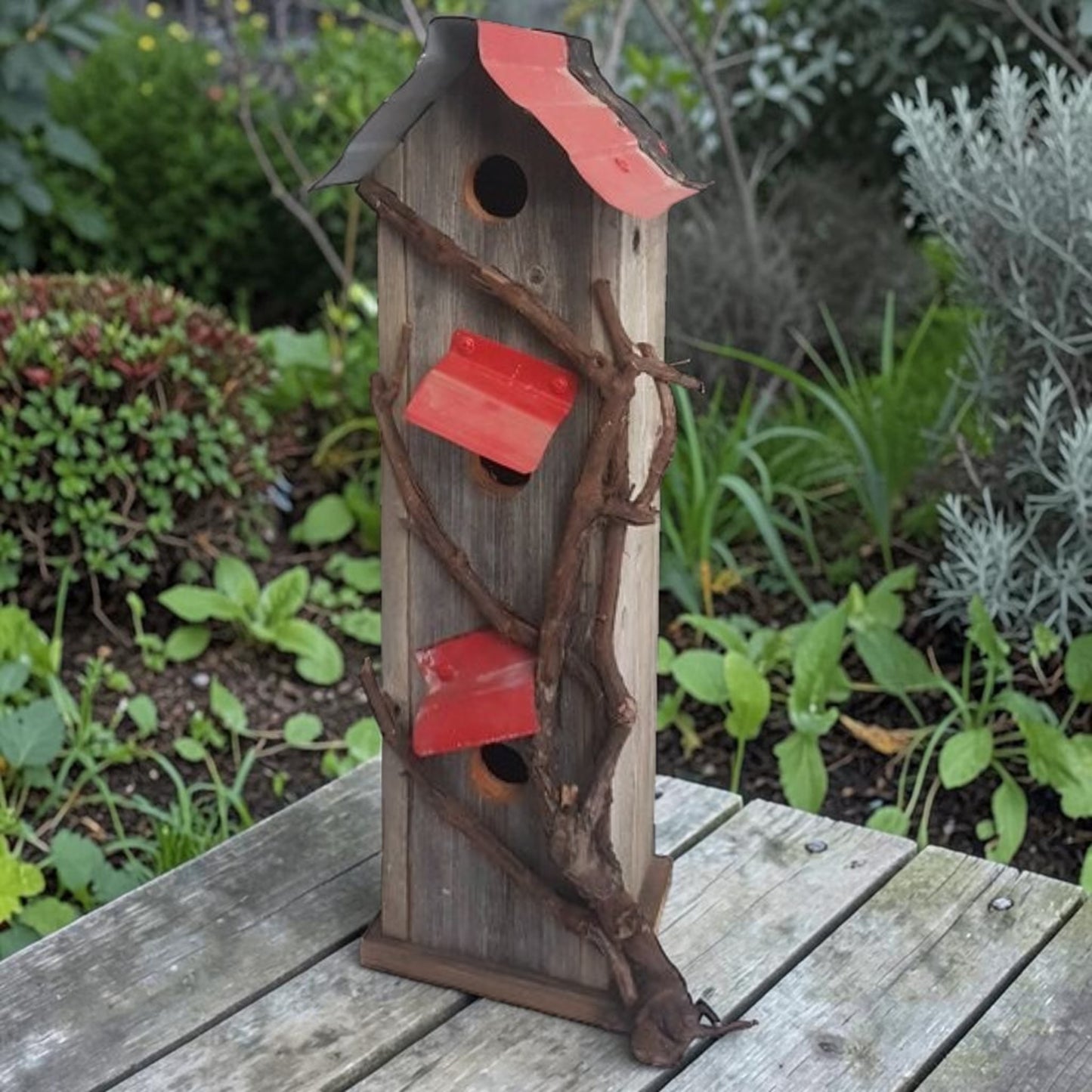 Handcrafted reclaimed cedar and barn tin birdhouse with three nesting spots.