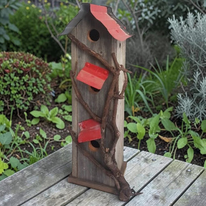 Handcrafted reclaimed cedar and barn tin birdhouse with three nesting spots.